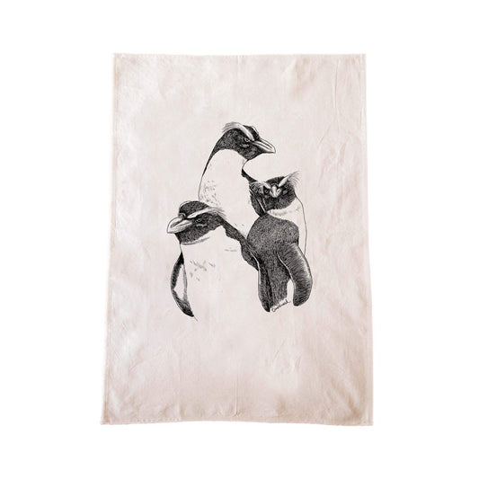 Off-white cotton tea towel with a screen printed Fiordland crested penguin/tawaki design.